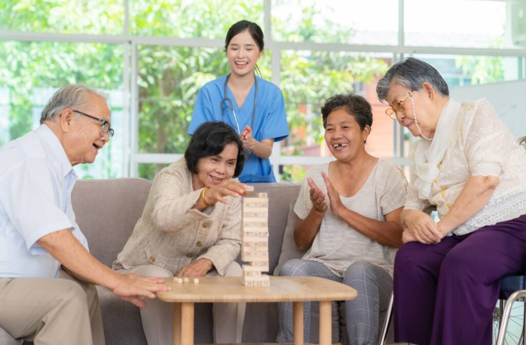 A group of seniors with dementia play a game of Jenga together during a morning activity in memory care
